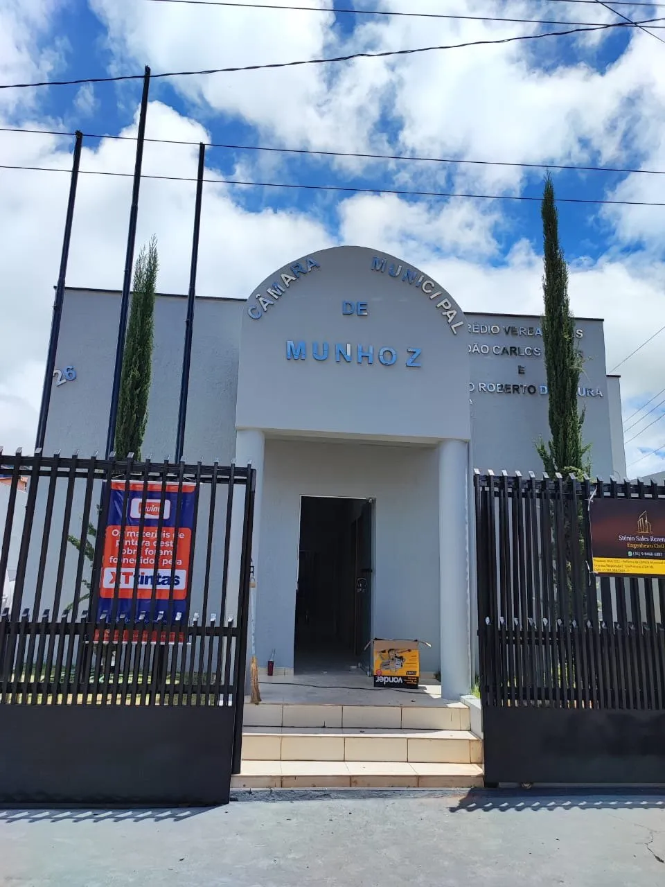 Fachada da Câmara Municipal de Munhoz após a pintura, com gradil e céu azul