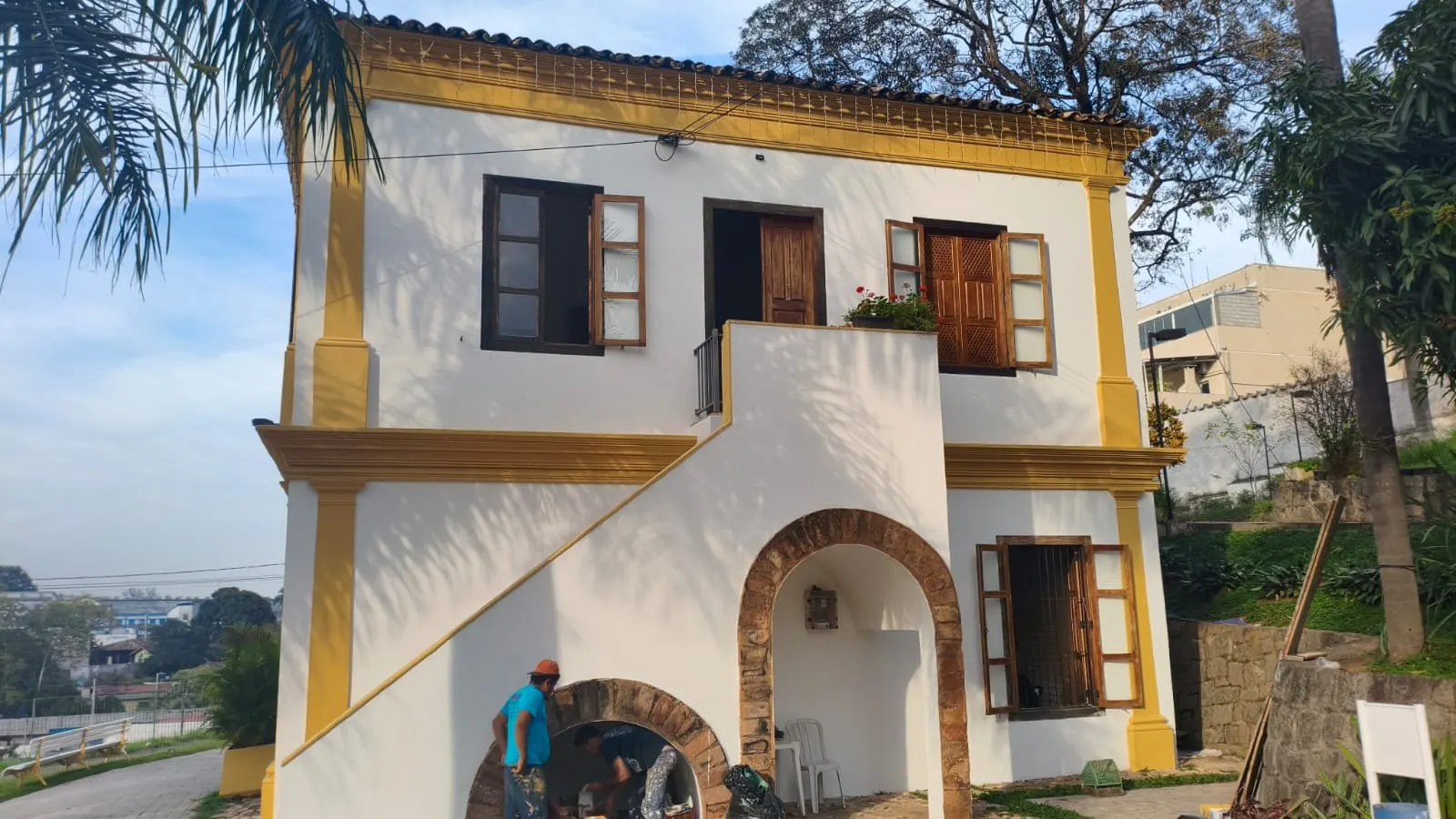 Escada externa e arco de tijolos na lateral do casarão