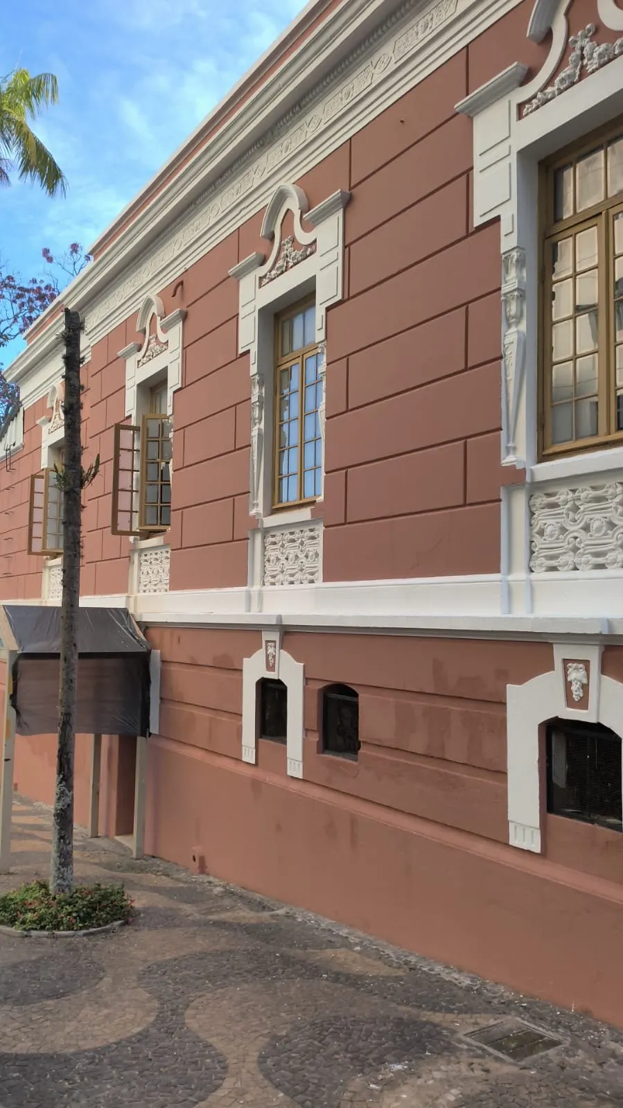 Fachada lateral em terracota com cimalhas e frisos brancos
