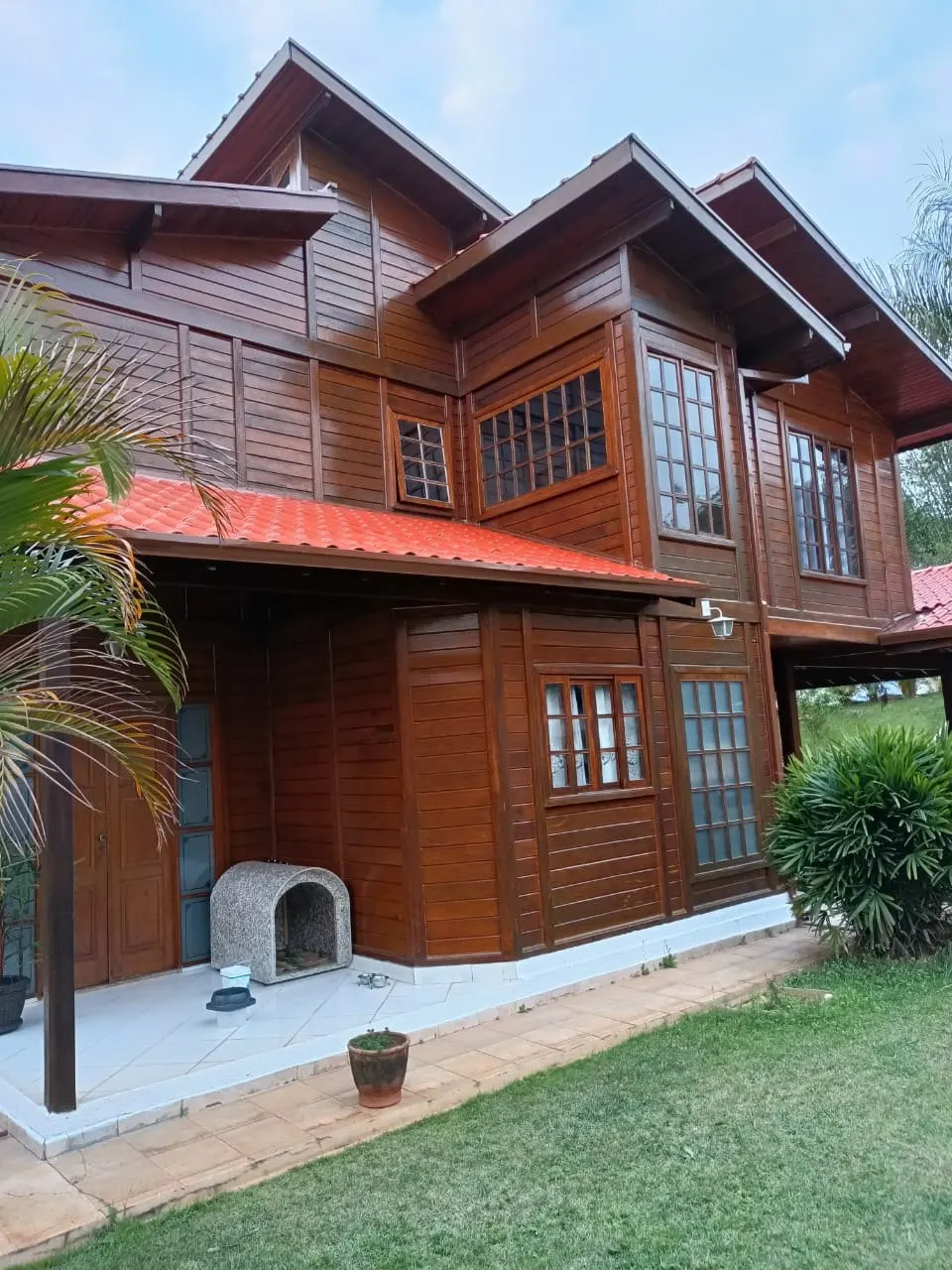 Fachada lateral com madeira em tom mogno após o verniz