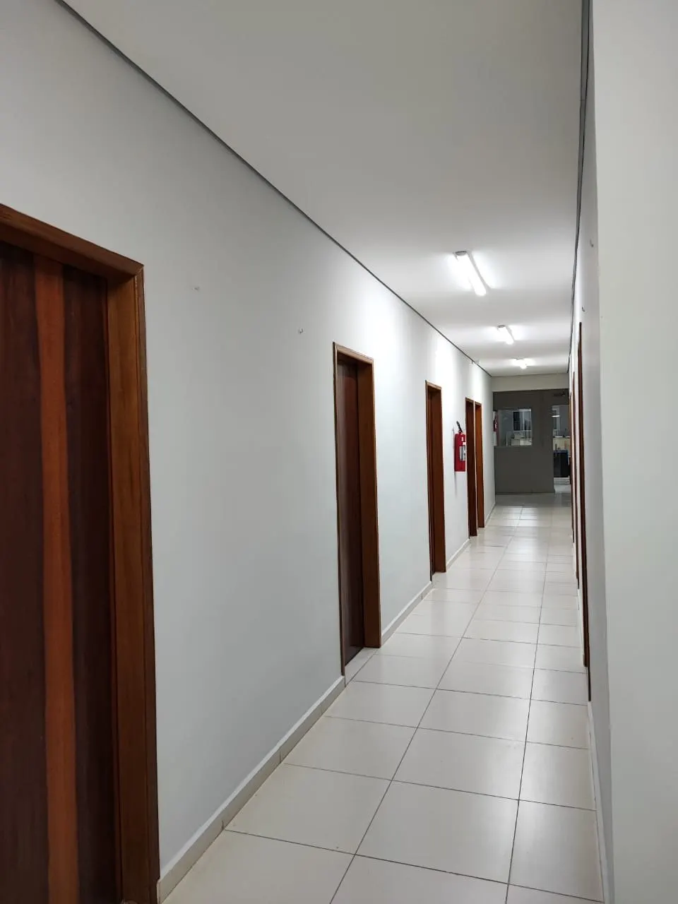 Corredor com portas de madeira e iluminação após a pintura