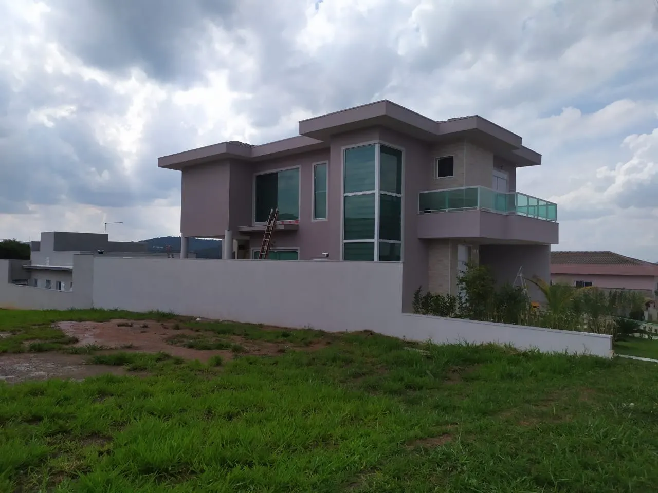 Casa em condomínio com fachada renovada vista do terreno