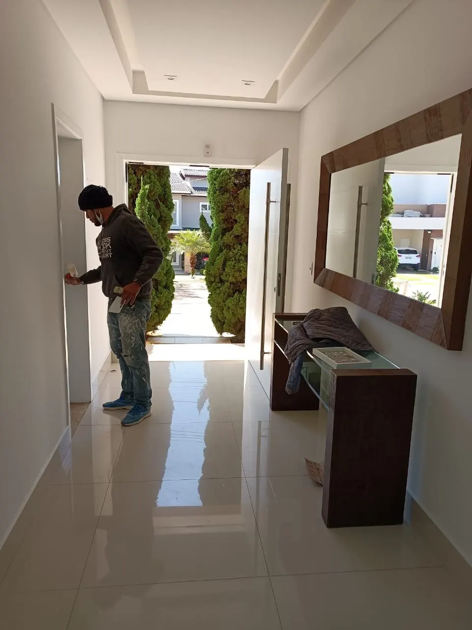 Hall de entrada com paredes novas e piso protegido durante a obra