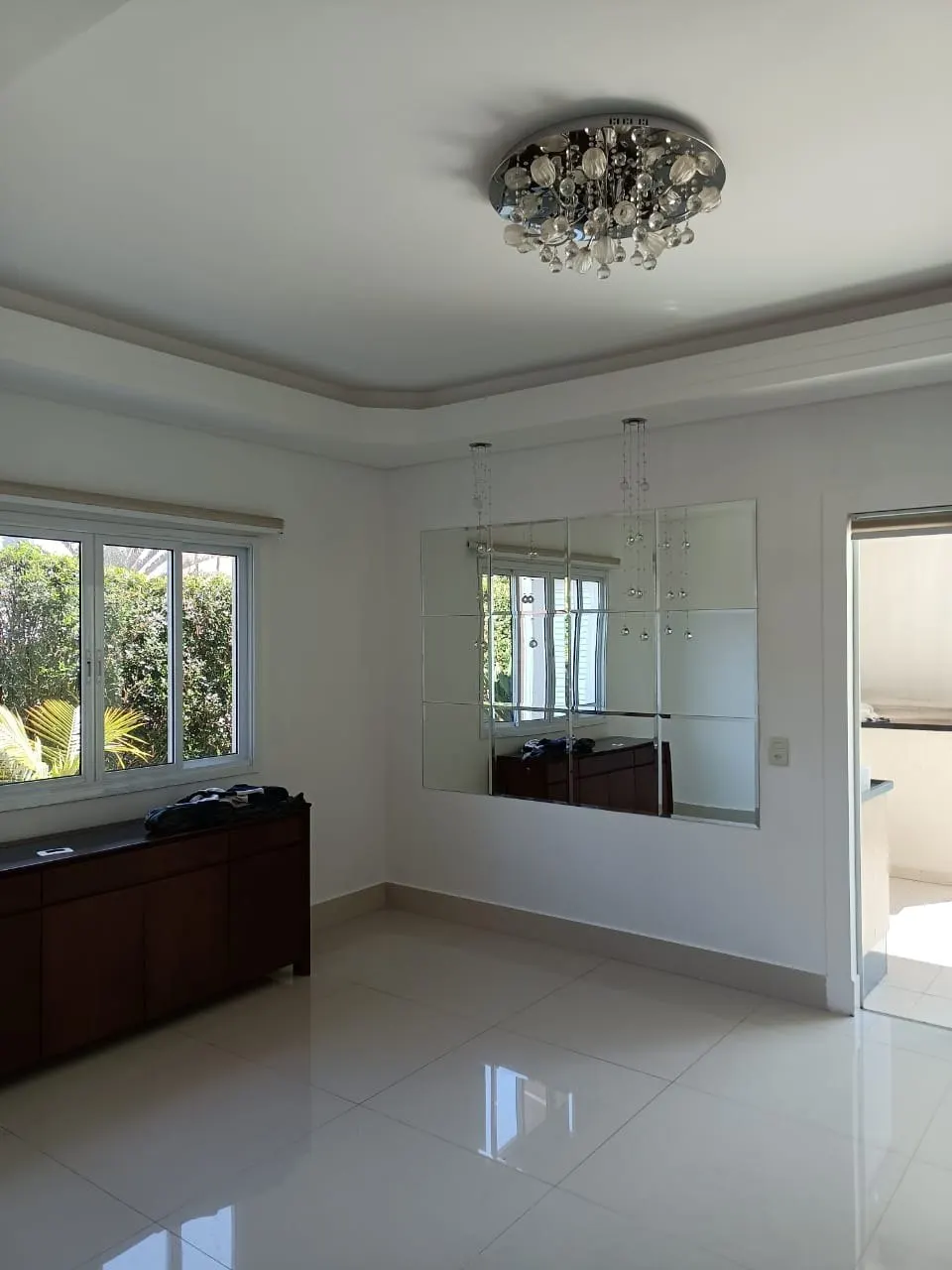 Sala com lustre e paredes brancas com acabamento uniforme