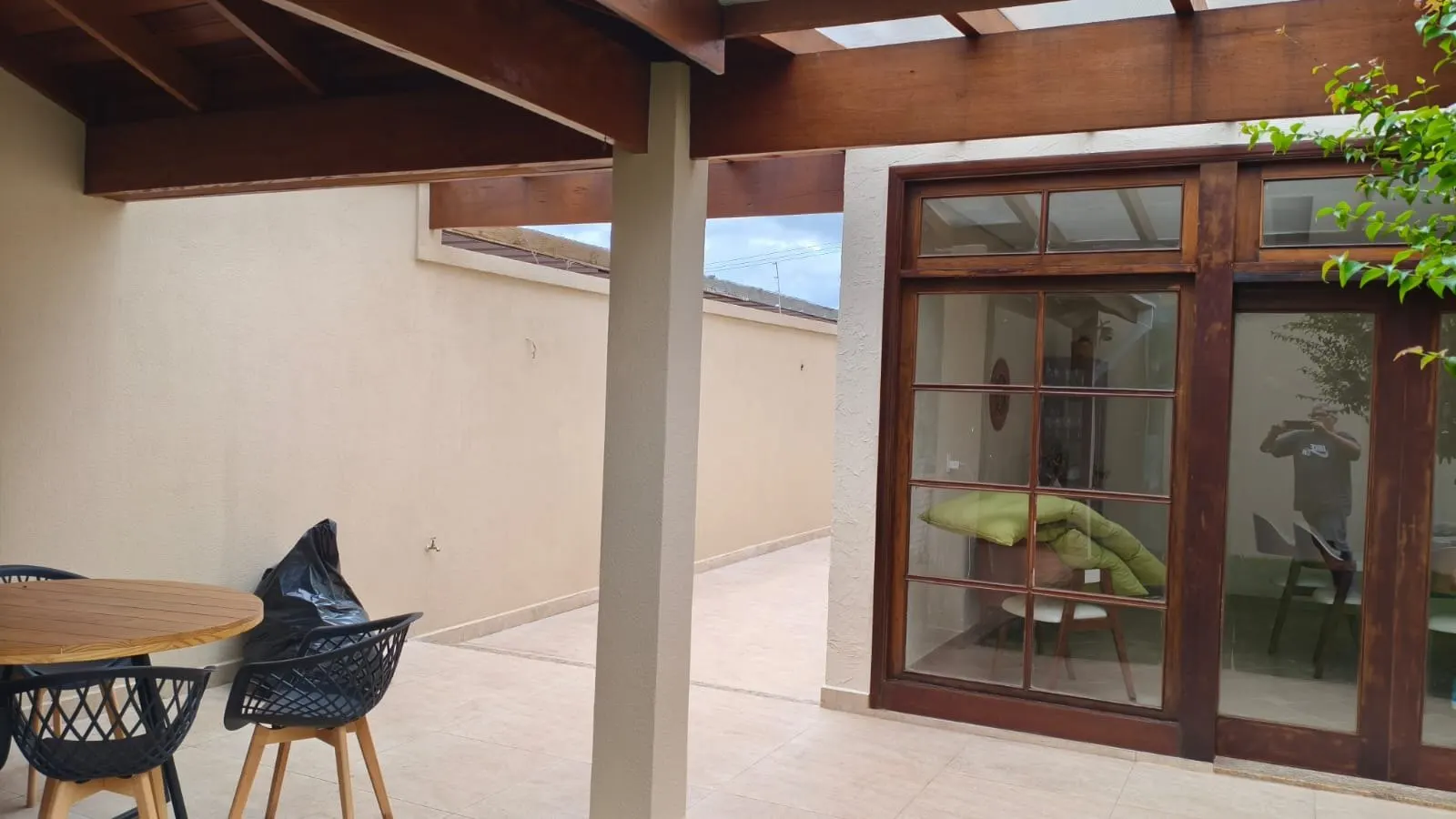 Varanda com pergolado de madeira e portas envernizadas